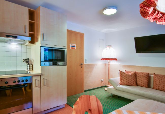 Woonkamer Desirè Alpenhaus Montafon Woonkamer met tafel, keuken en bank Desirè Alpenhaus Montafon