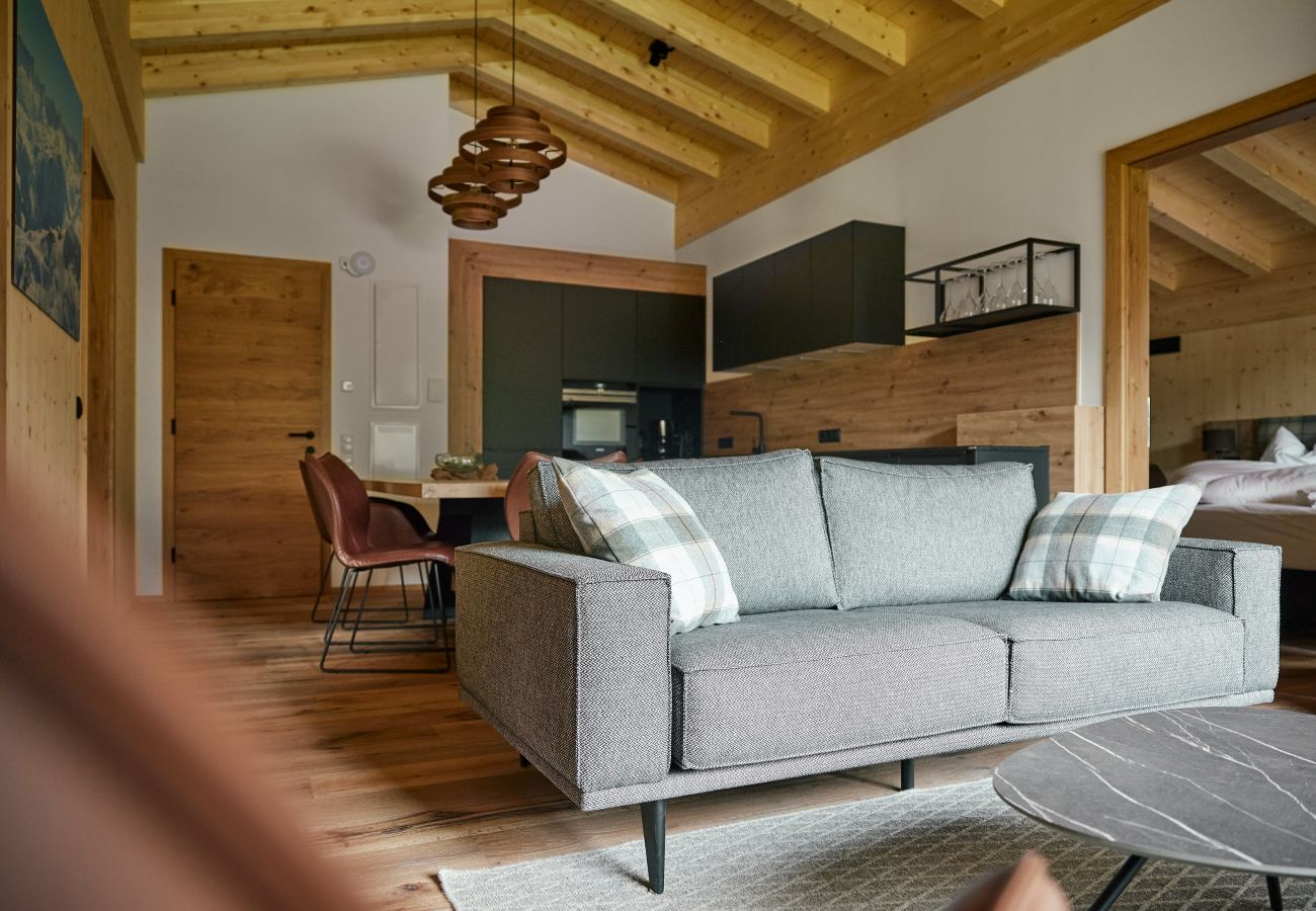 Woonkamer Alm Lodge 1 Bank met zicht op de slaapkamer in Alm Lodge 1