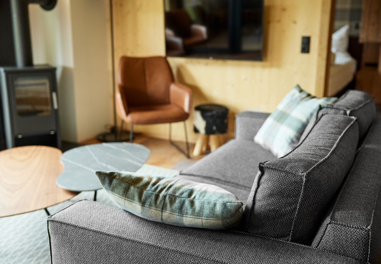 Woongedeelte Alm Lodge 1 Bank met tv op de achtergrond in Alm Lodge 1