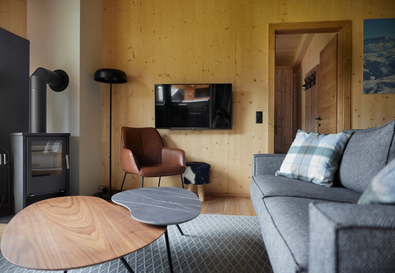 Woonkamer Alm Lodge 1 Bank met open haard en tv in Alm Lodge 1
