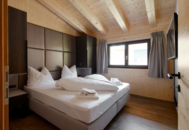 Slaapkamer Alm Lodge 4 Slaapkamer met een tweepersoonsbed en twee kledingkasten in de Alm Lodge 4