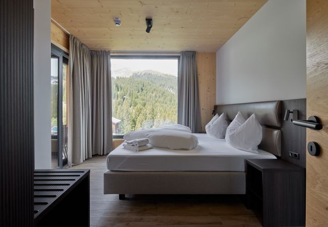 SlaapkamerAlm Lodge 4 Slaapkamer met tweepersoonsbed en prachtig uitzicht in de Alm Lodge 4
