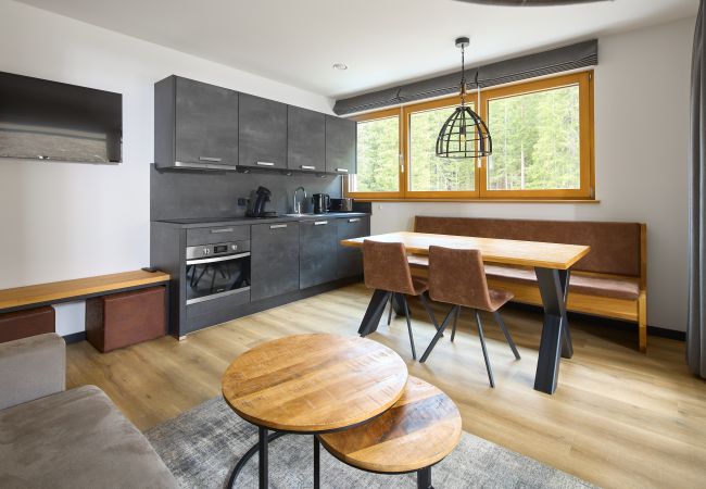 Woonkamer met bank, tafel en keuken in het Fels-Schwalbe 115 Alpin-Resort Montafon