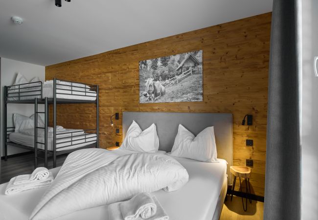 Slaapkamer Alpen-Dohle 202 Alpin-Resort Montafon Slaapkamer met tweepersoonsbed en stapelbed in het Alpen-Dohle 202 Alpin-Resort Montafon