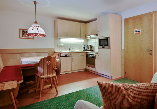 Living room Desirè Alpenhaus Montafon Living area with kitchen and table in the Desirè Alpenhaus Montafon