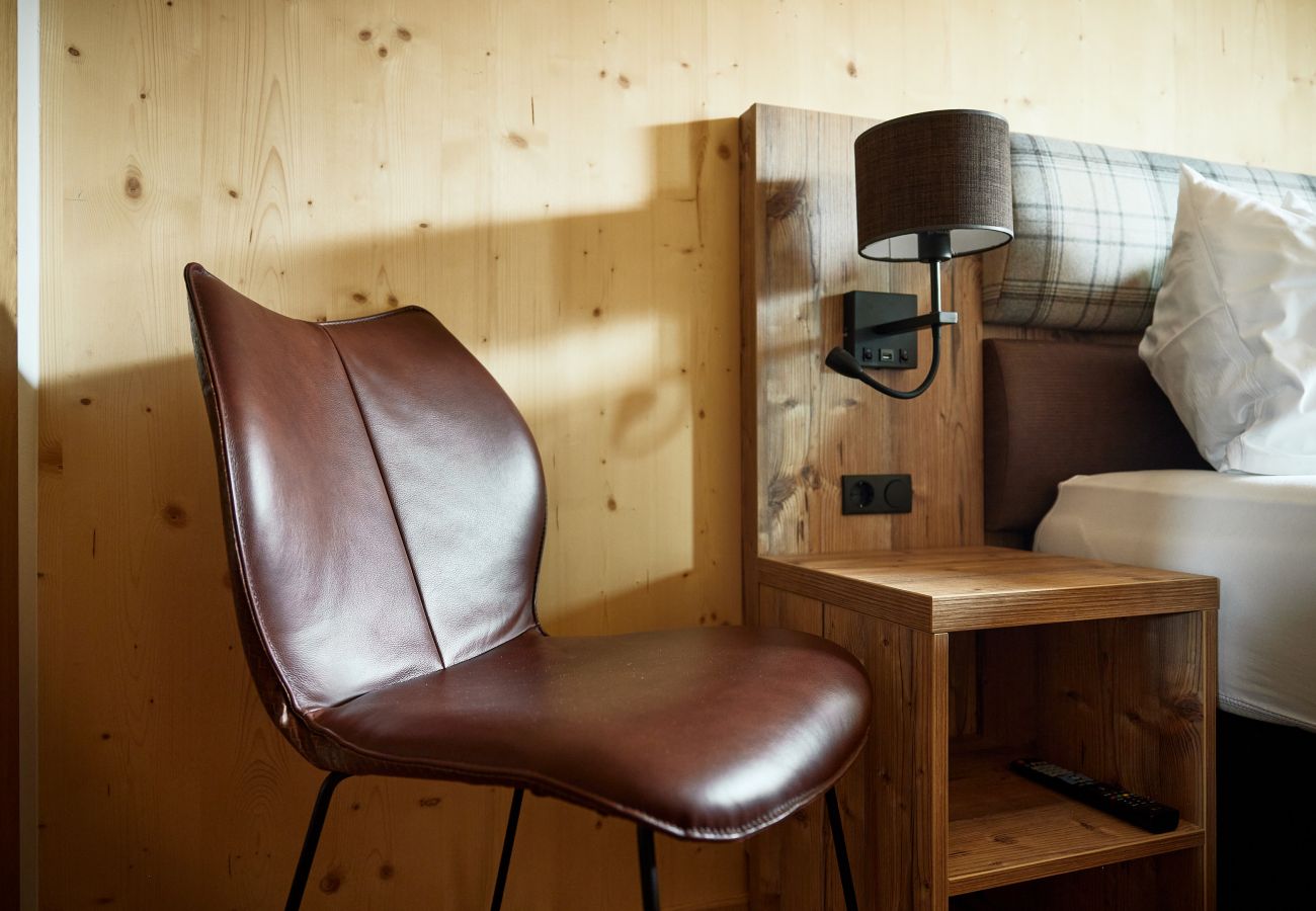 Bedroom Alm Lodge 1 Chair with bedside table and bed in Alm Lodge 1