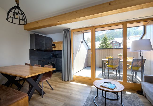 Living area with sofa, table and kitchen in the Mauerläufer 324 Alpin-Resort Montafon