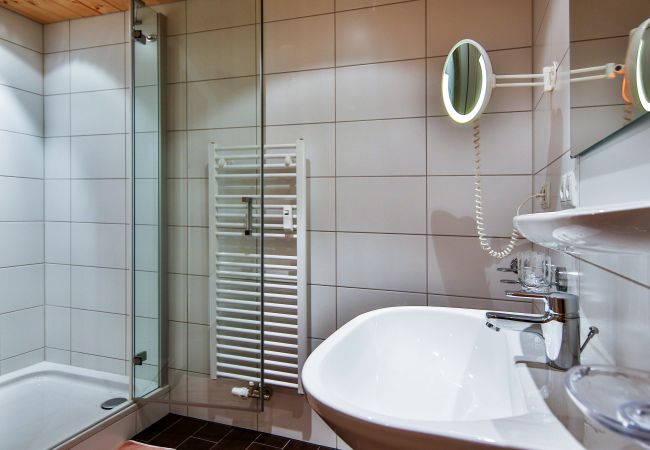 Bad Desirè Alpenhaus Montafon Bad mit Klo, Dusche und Waschbecken im Desirè Alpenhaus Montafon