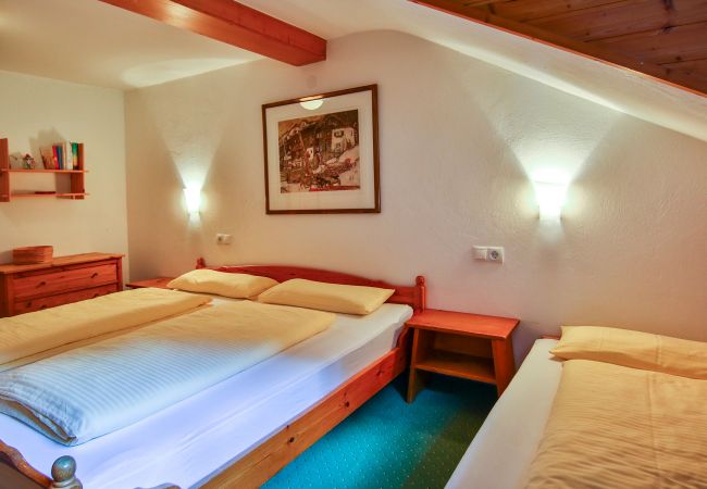 Schlafzimmer mit Doppelbett im Erika Alpenhaus Montafon Schlafzimmer mit Doppelbett und einem Einzelbett im Erika Alpenhaus Montafon