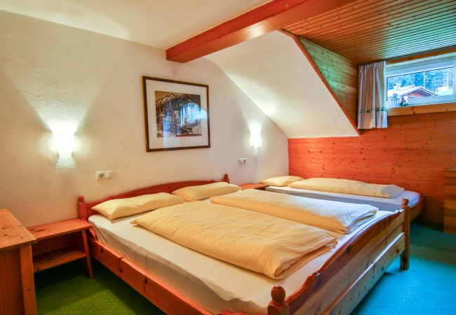 Schlafzimmer Erika Alpenhaus Montafon Schlafzimmer mit Doppelbett und einem Einzelbett im Erika Alpenhaus Montafon