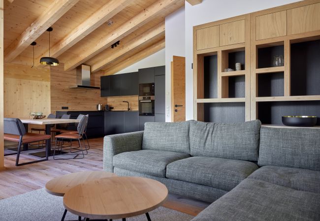 Wohnbereich Alm Lodge 5 Wohnbereich mit Sofa und Tisch im Hintergrund in der Alm Lodge 5