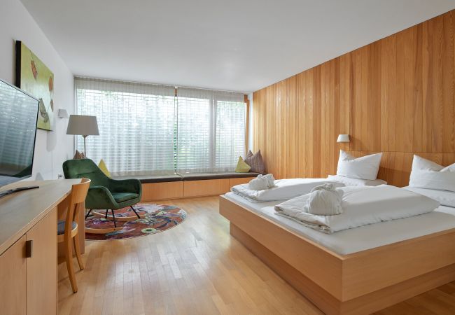 Schlafzimmer mit Doppelbett und Sessel im Panorama Apartment Bonawinkel