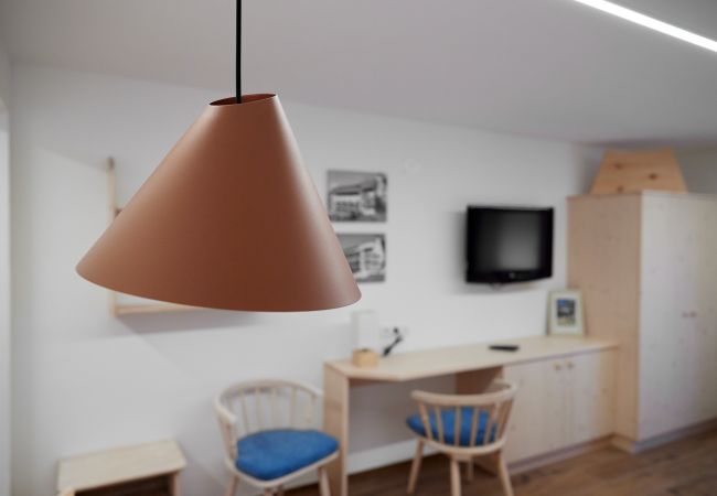 Wohnbereich Alice Alpenhaus Montafon Wohnbereich mit Lampe und einem Tisch im Hintergrund im Alice Alpenhaus Montafon