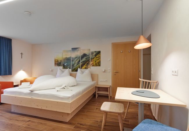 Wohnbereich Alice Alpenhaus Montafon Wohnbereich mit Tisch und Schlafzimmer im Alice Alpenhaus Montafon