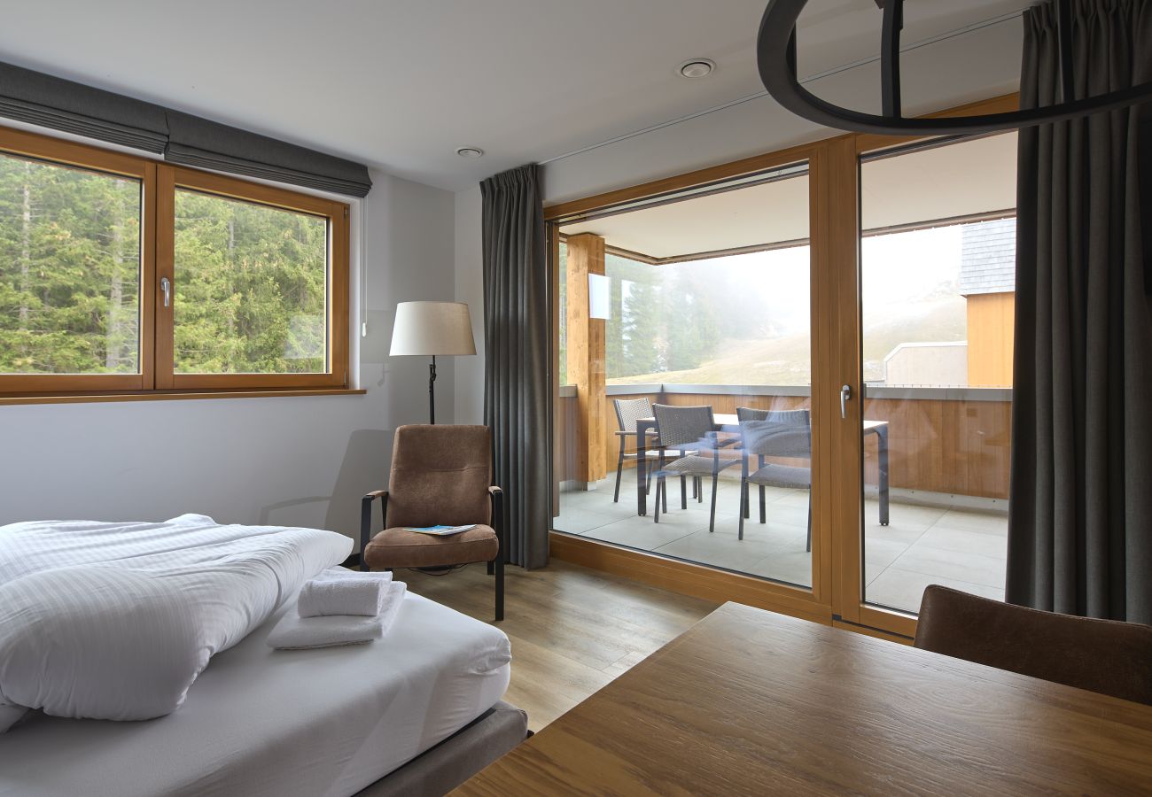 Wohnbereich mit Bett und Tisch im Specht 109 Alpin-Resort Montafon