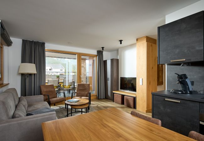 Wohnbereich mit Sofa, Tisch und Küche im Alpen-Dohle 202 Alpin-Resort Montafon