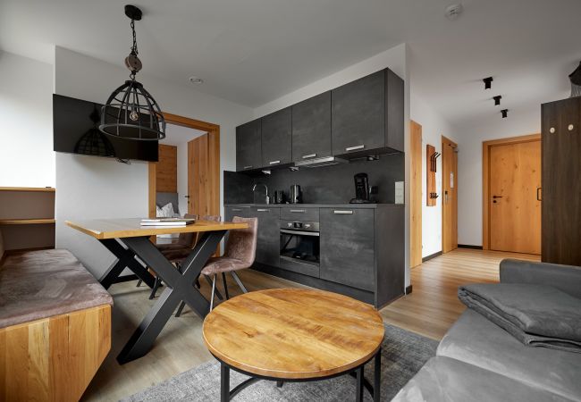 Wohnbereich Wanderfalke 116 Alpin-Resort Montafon Wohnbereich mit Küche und Tisch in der Wanderfalke 116 Alpin-Resort Montafon