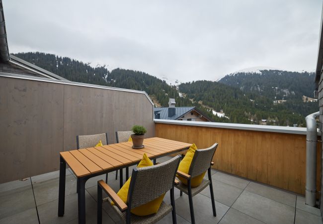 Dachterasse Wanderfalke 116 Alpin-Resort Montafon Dachterasse mit Stühlen und einem Tisch im Wanderfalke 116 Alpin-Resort Montafon