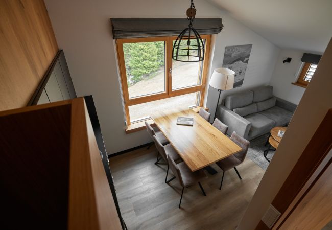 Wohnbereich Bartgeier 119 Alpin-Resort Montafon Wohnbereich mit Sofa, Tisch und Küche im Bartgeier 119 Alpin-Resort Montafon