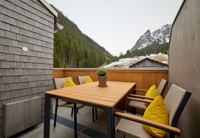 Dachterasse Bartgeier 119 Alpin-Resort Montafon Dachterasse mit Stühlen und einem Tisch im Bartgeier 119 Alpin-Resort Montafon